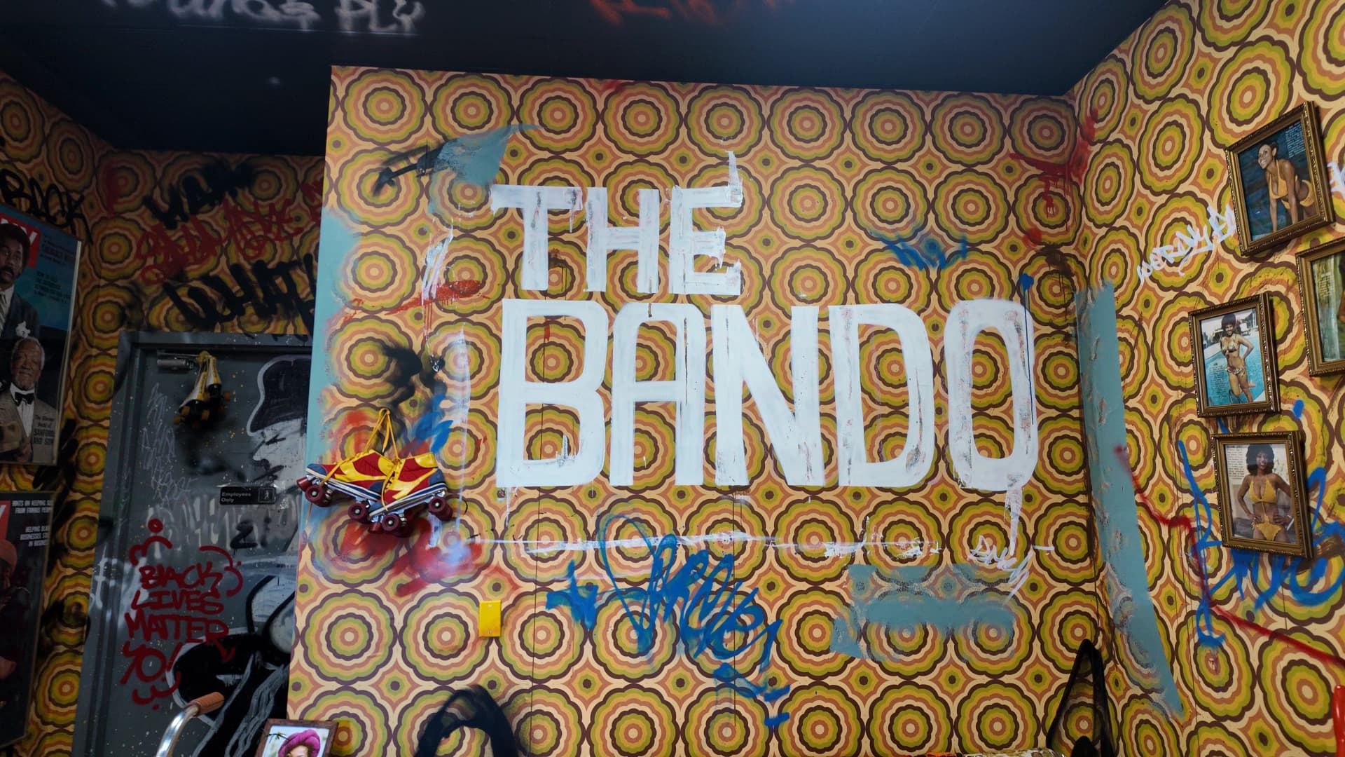 The Bando wordmark hand-painted at mural scale across a retro patterned wall inside the venue