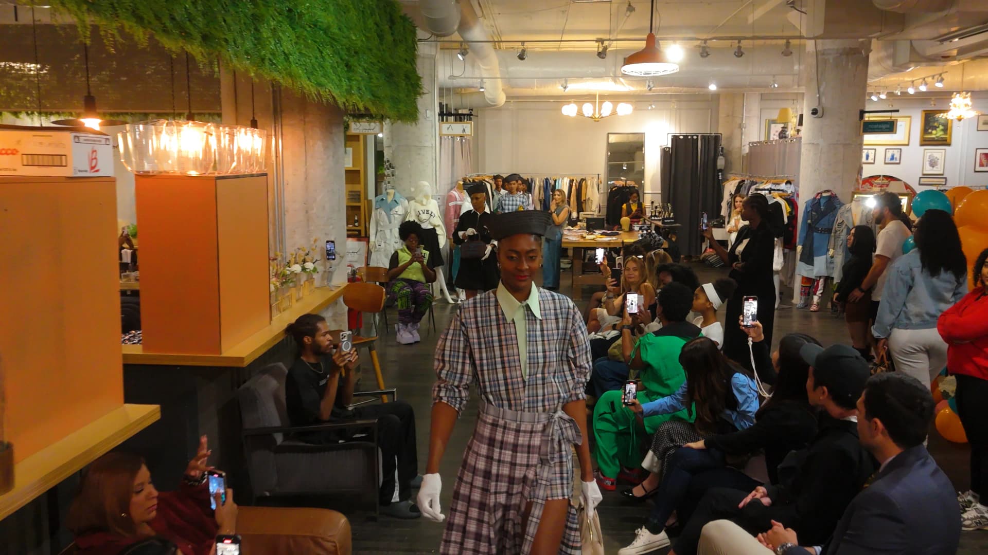 A model walking a runway show inside Ikna's Atlanta retail space during a branded event