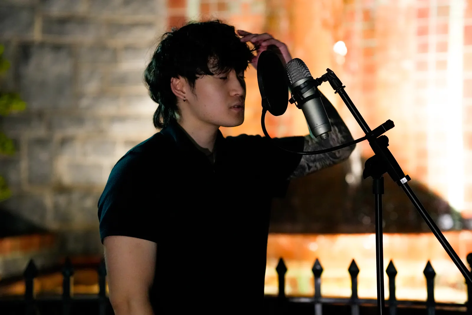 A vocalist with eyes closed singing into a microphone